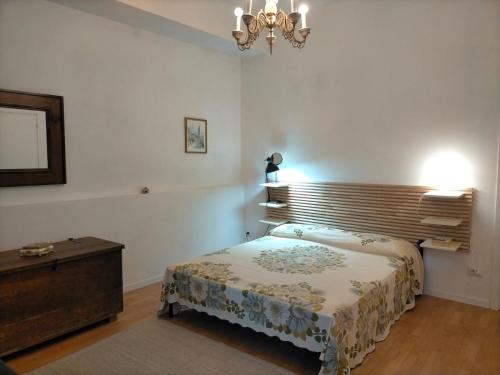 a bedroom with a bed and a chandelier at Mamè Guest House in Figlino