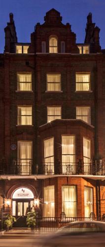 a large brick building with windows at night at Nottingham Place Hotel in London