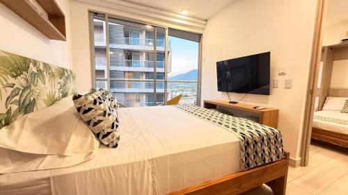 a bedroom with a large bed and a large window at Bello Horizonte, Aeropuerto, playa Dormida in Santa Marta
