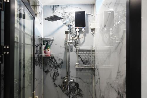 a bathroom with a shower with marble walls at Nadi Easy Home Near McDonalds in Nadi