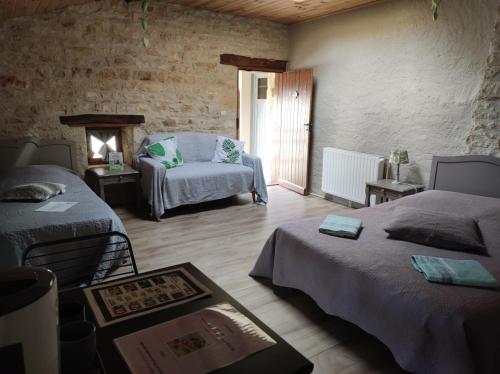 a room with two beds and a chair and a fireplace at Les Chenets in Chenay