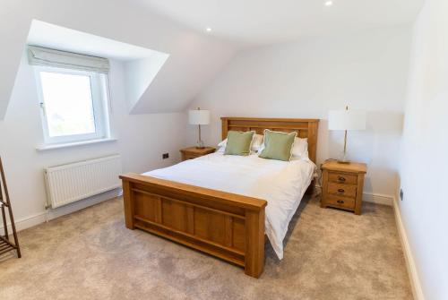 a bedroom with a large bed and a window at 5 The Cloisters - Waterville in Waterville