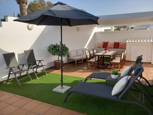 a patio with an umbrella and a table and chairs at LEIDA - Relax y privacidad in Cala Blanca