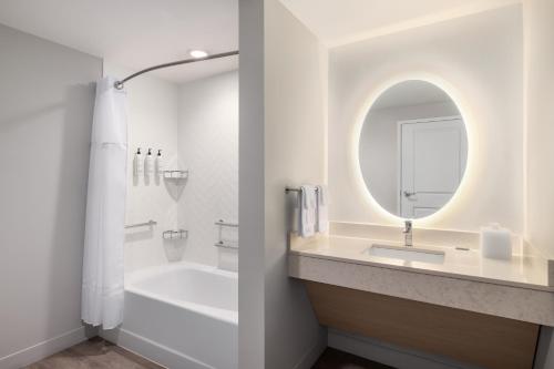 a bathroom with a tub and a sink and a mirror at TownePlace Suites by Marriott Hickory in Hickory