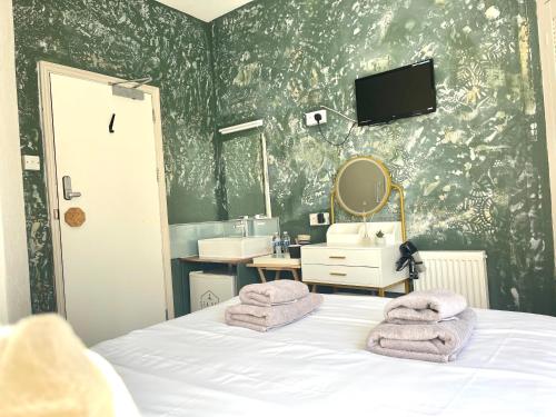a bedroom with a bed and a sink and a mirror at Sea Bed Guesthouse in Newquay