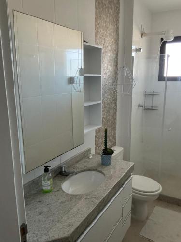 a bathroom with a sink and a toilet and a mirror at Lisboa Hospedaria 300 m da praia do forte in Cabo Frio