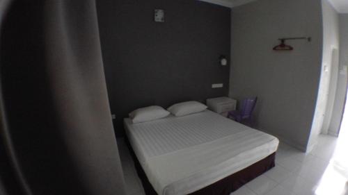 a small bedroom with a bed with two white pillows at TEBiNG Guest House Taman Negara Malaysia Kuala Tahan in Kuala Tahan