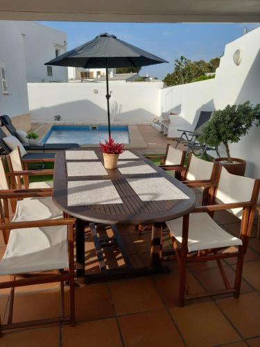 a table and chairs with an umbrella on a patio at LEIDA - Relax y privacidad in Cala Blanca