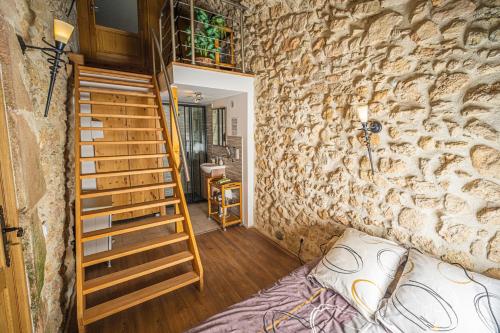 a room with a stone wall and a staircase at Au Château de Villelongue B&B in Villelongue-dʼAude