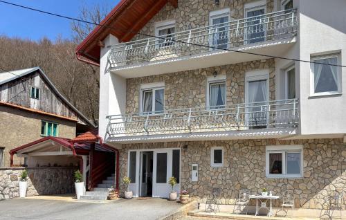 a large stone building with a balcony and a table at Gorgeous Home In Buzim in Bužim