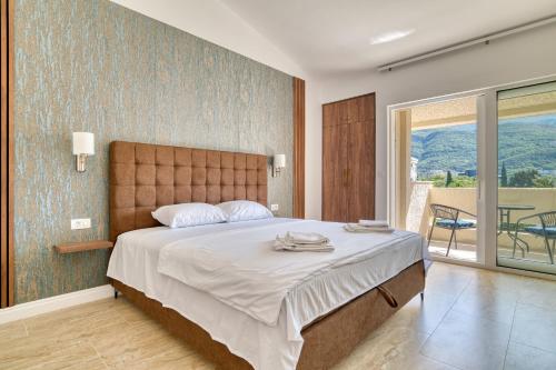 ein Schlafzimmer mit einem großen Bett und einem Balkon in der Unterkunft Gama residence in Becici
