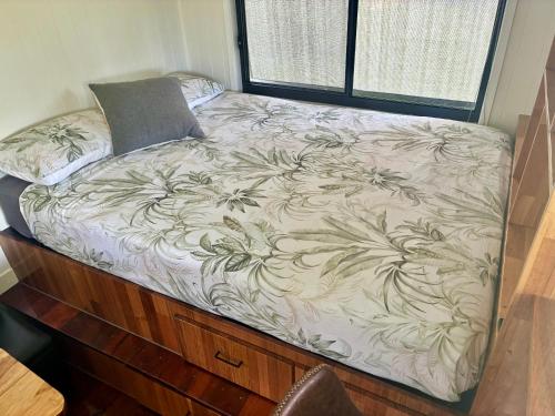a bed on a wooden dresser in a room at Bee Farm Off-Grid Tiny Home Stay in Tamaree