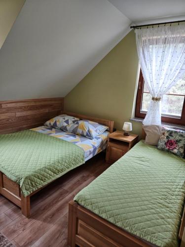 a bedroom with two beds and a window at Agroturystyka Pod Sosnami w Atenach in Nowinka