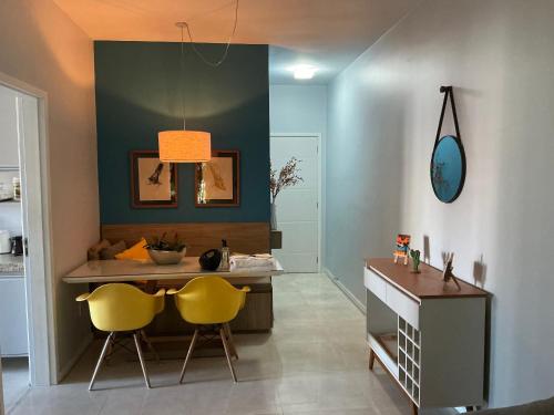 a room with two yellow chairs and a desk at Lisboa Hospedaria 300 m da praia do forte in Cabo Frio