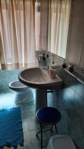 a bathroom with a sink and a mirror and two toilets at Olympus in Paola