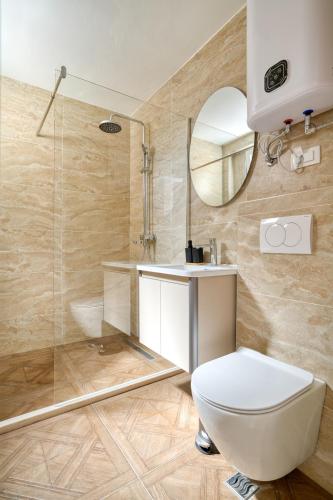 ein Badezimmer mit Toilette, Waschbecken und Spiegel in der Unterkunft Gama residence in Becici