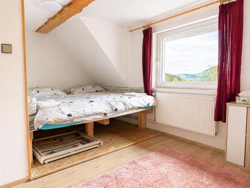 a small bedroom with a bed and a window at Chalupa Kukajda in Desná