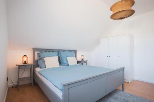 a bedroom with a large bed with blue sheets at Fernruh Eifel in Dahlem
