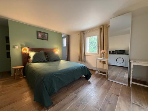 a bedroom with a bed with a green comforter at Studio vert à 400 m de la plage in Le Pradet