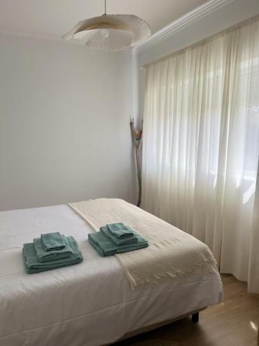 a bedroom with a bed with two towels on it at Furadouro Cool & Cozy Flat in Furadouro