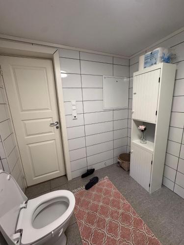 a bathroom with a white toilet and a door at Central leilighet i Kristiansand Vågsbygd in Kristiansand