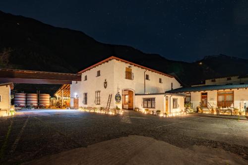 a large white building with lights in the night at Dimora Perla di Villa - Spacious Wine Estate Retreat near Bernina Express in Villa di Tirano