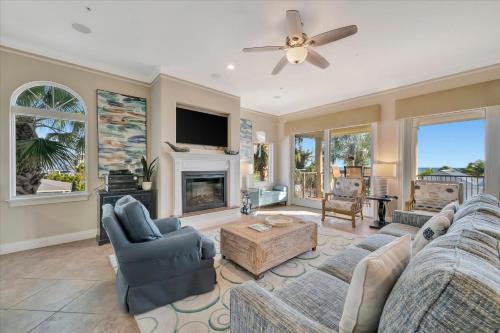 a living room with two couches and a fireplace at 3B Beachfront Condo - Heated Pool & 18ft Balcony in Holmes Beach