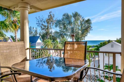 a table and chairs on a balcony overlooking the ocean at 3B Beachfront Condo - Heated Pool & 18ft Balcony in Holmes Beach