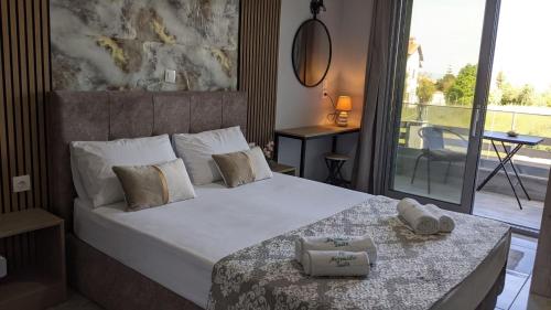 a bedroom with a large bed with towels on it at Artemida Suites in Hanioti