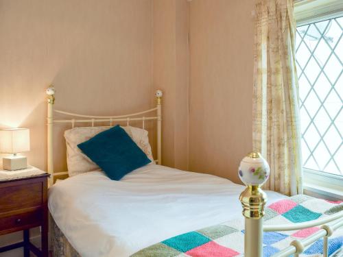 a bedroom with a bed and a window at Rebecca's Cottage in Ashby Saint Ledgers