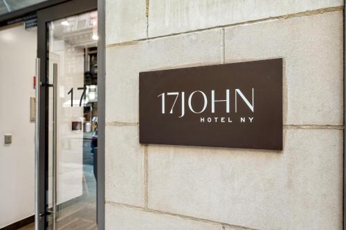 ein Schild an der Seite eines Gebäudes in der Unterkunft 17John in New York