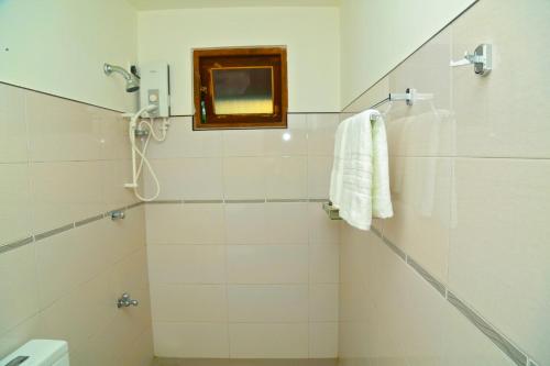 ein Badezimmer mit Dusche mit Spiegel und Waschbecken in der Unterkunft 4 S Villa in Tangalle
