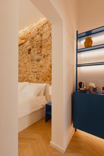 a bedroom with a bed and a brick wall at Andrew suites in Nettuno