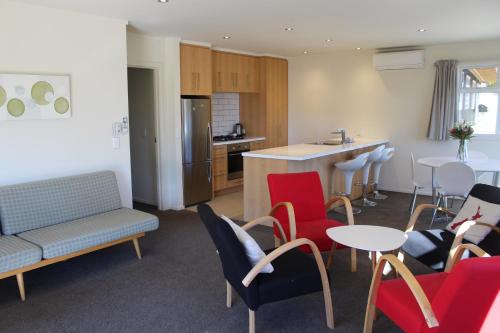 a kitchen and a living room with chairs and a table at Matagouri Cottage - Lake Tekapo in Lake Tekapo