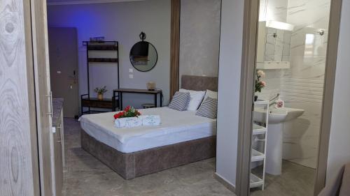 a bedroom with a bed and a sink and a bathroom at Artemida Suites in Hanioti