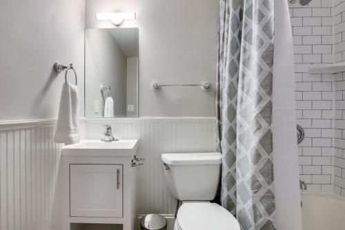 a white bathroom with a toilet and a sink at Historic Downtown Marble Falls- 2 Suite Combo 13 in Marble Falls