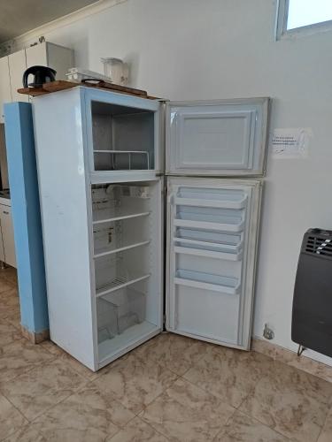 a white refrigerator with its door open in a kitchen at Espacio Pueyrredón in Comodoro Rivadavia
