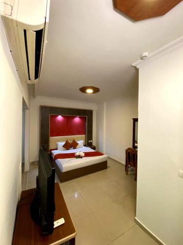 a bedroom with a bed and a desk with a television at Elysee Residence in Beirut