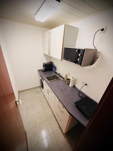 a small kitchen with a sink and a microwave at Familie-Ising aus de in Unterwörnitz