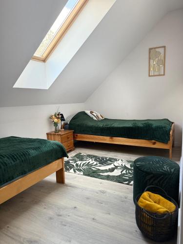 a attic room with two beds and a rug at Bezdroża Mazurskie in Mrągowo