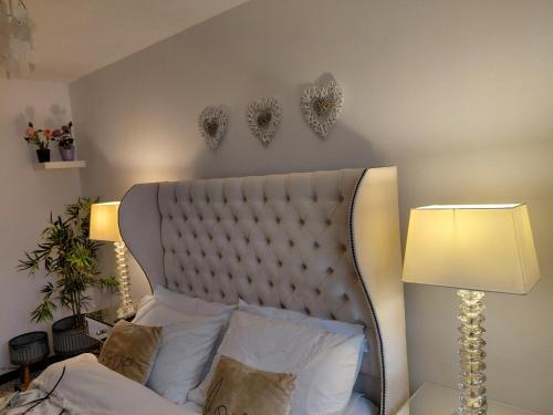 a bedroom with a white bed with two hearts on the wall at Little Nuek in Largs