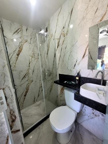 a bathroom with a toilet and a shower and a sink at terraço do peró cabo frio pousada in Cabo Frio
