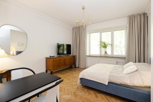 a bedroom with a bed and a mirror and a table at Sienna Central Studio & Parking in Warsaw