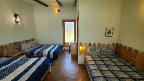 a room with two beds and a chair in it at Bungalow con alberca Privada y Climatizada en Tequisquiapan in Tequisquiapan