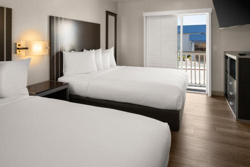 a hotel room with two beds and a balcony at Sand Castle Inn in Seaside