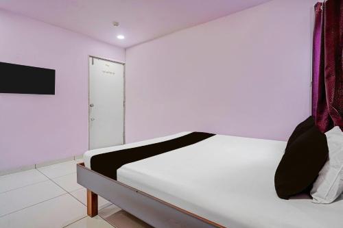 a bedroom with a bed and a door in it at Hotel O Unity Guest House in Dabhoi