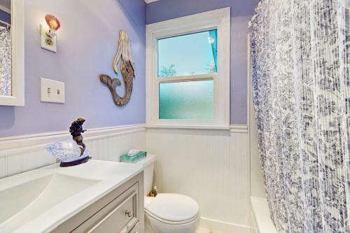 a bathroom with purple walls and a toilet and a window at Eagle Harbor House World Cup Availability in Winslow
