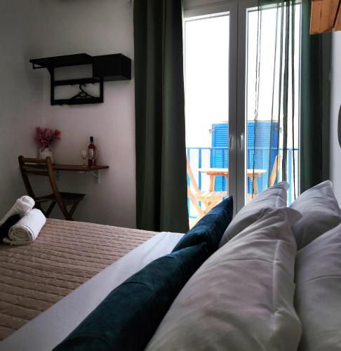 a bedroom with a bed with a view of a balcony at Kato Yialos Paros in Parikia