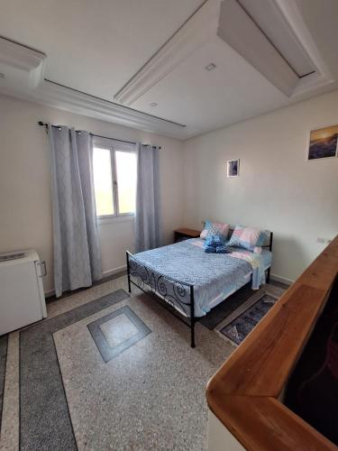 a bedroom with a bed and a window at Résidence Zaouit Aglou in Aglou