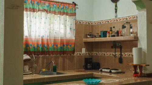 a kitchen with a sink and a shower curtain at Casa Palagui Colonial in Valladolid